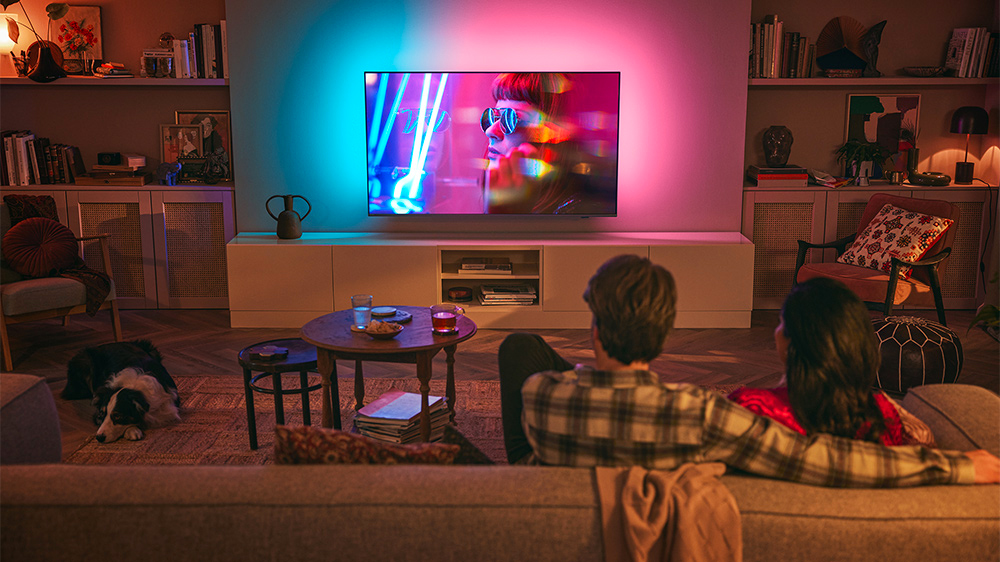 Muž se ženou sledují LED televizi Philips s osvětlením Ambilight_02