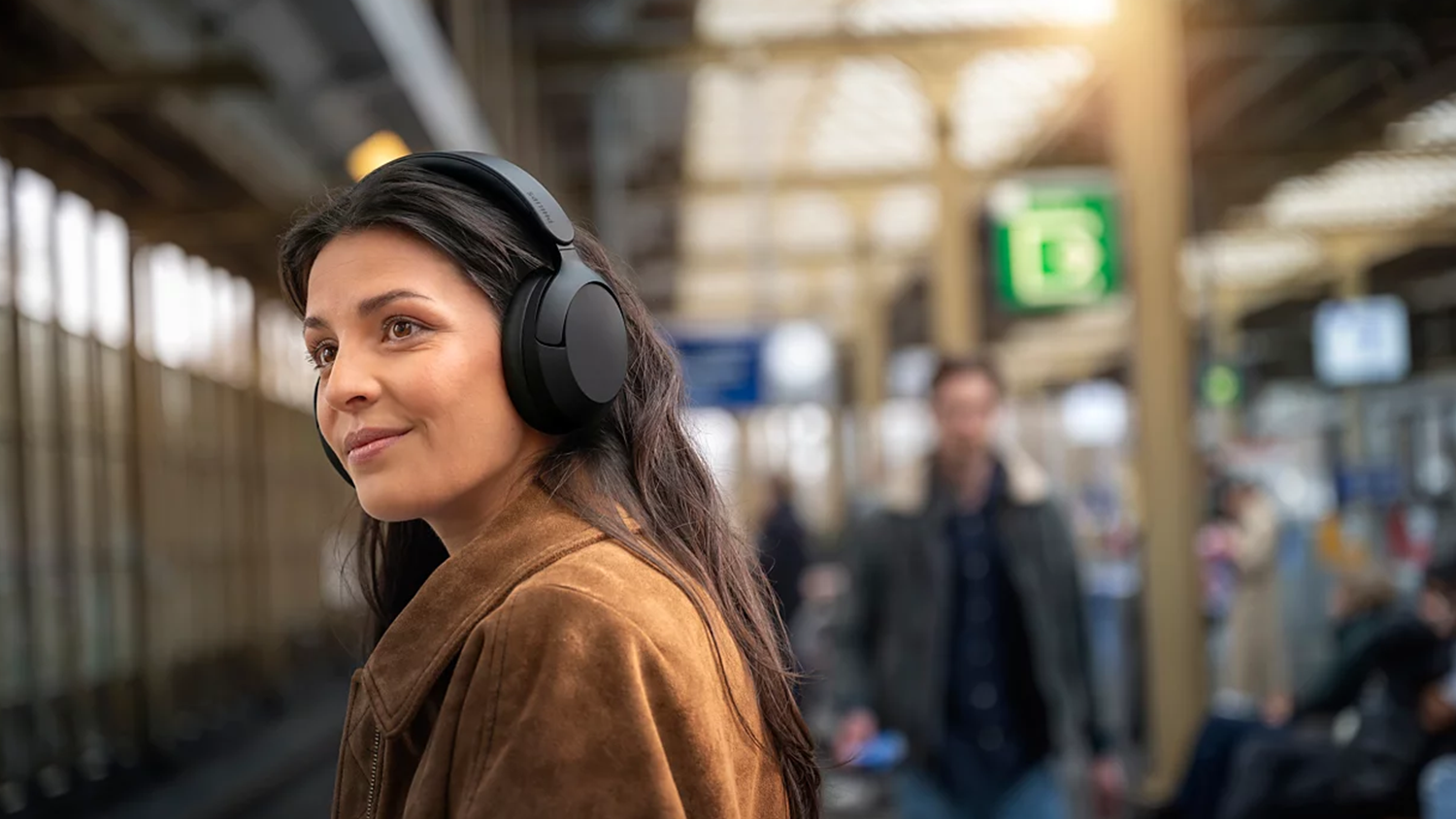 Žena v metre s bezdrôtovými slúchadlami Philips TAH6000BK/00 nasadenými na hlave