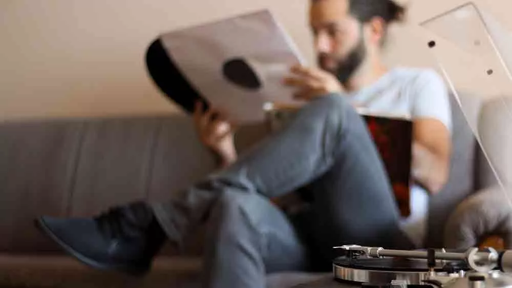 Muž na pohovke drží vinylovú platňu_02