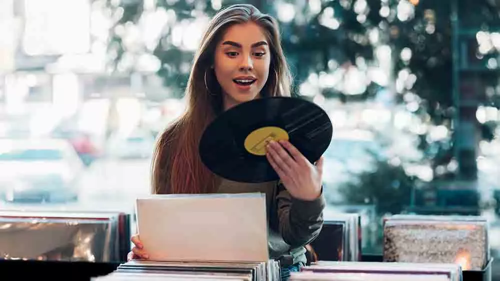 Žena si vyberie vinyl dosku