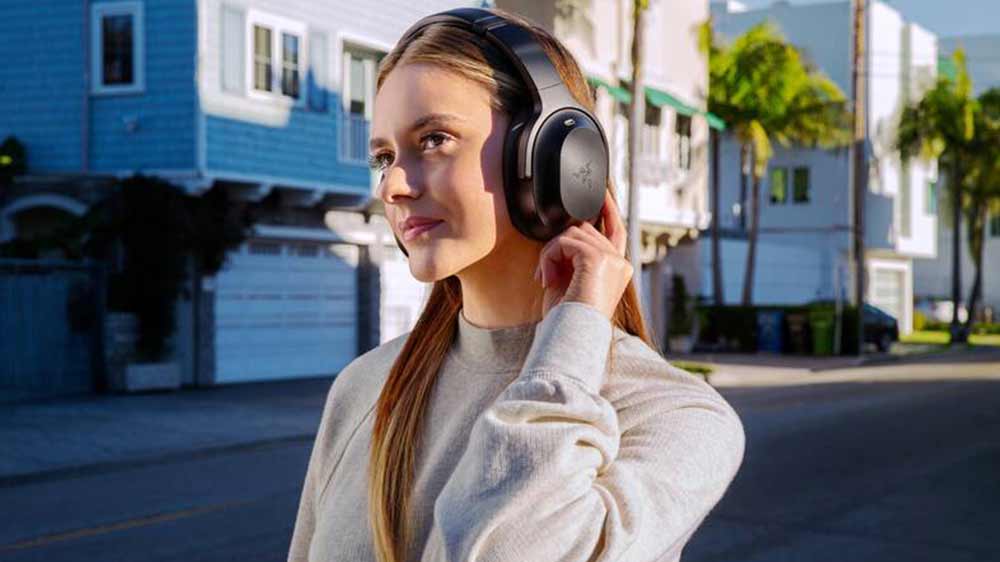 Dívka ovládá headset Razer Barracuda Pro stiskem tlačítka na těle sluchátka_04