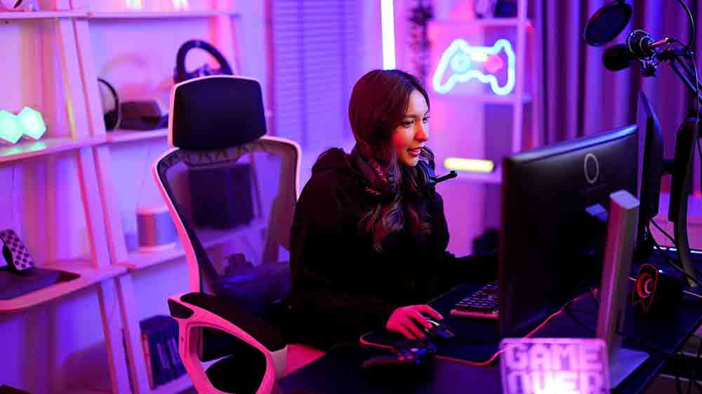 Mladá žena hrající PC hru v pokoji s neonovým osvětlením místnosti_03