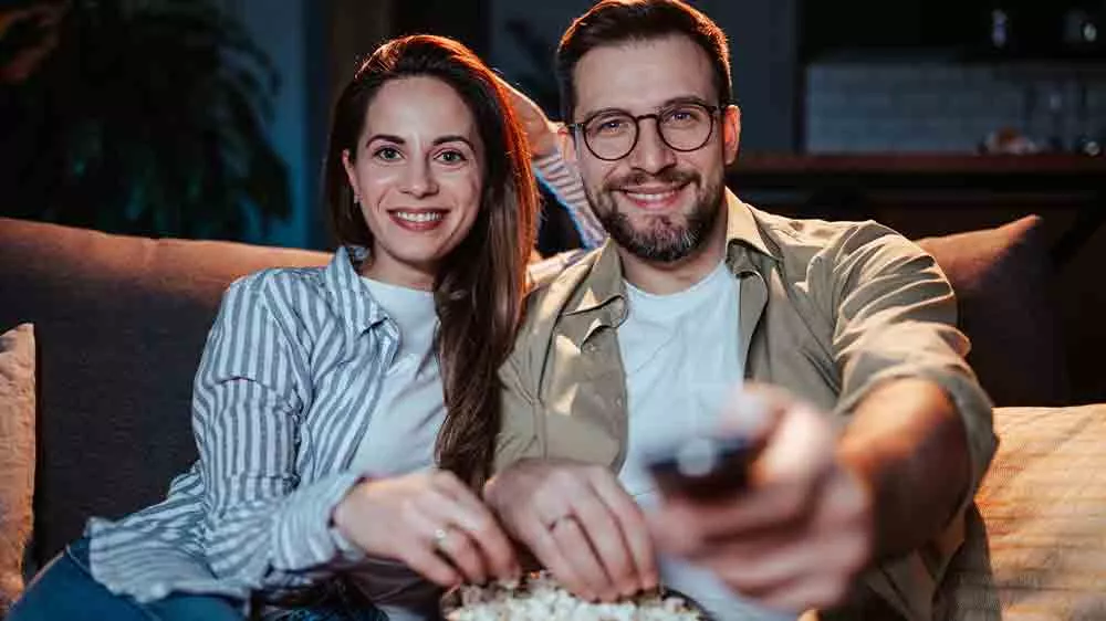 Pár na gauči sleduje televizi_05