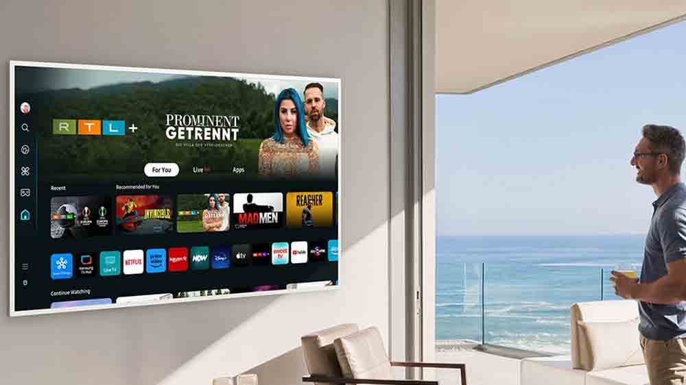 Muž d&iacute;vaj&iacute;c&iacute; se na obrazovku televize Samsung, na kter&eacute; je spousta aplikac&iacute; _07