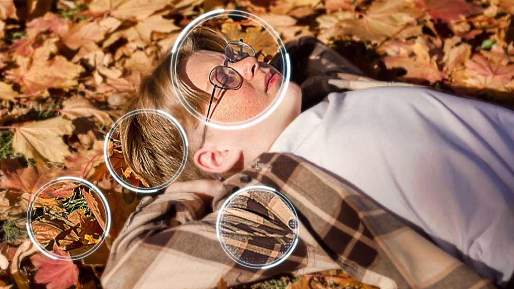 Záběr na chlapce ležícího v popadaném listí, který je místy lépe zaostřený_02