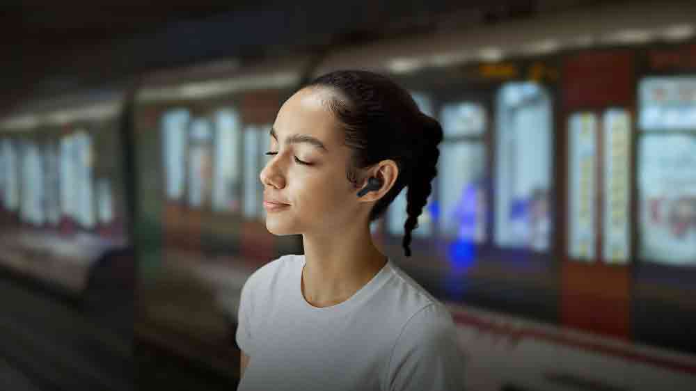 Žena, která má v uších bezdrátová sluchátka a v pozadí je metro_05