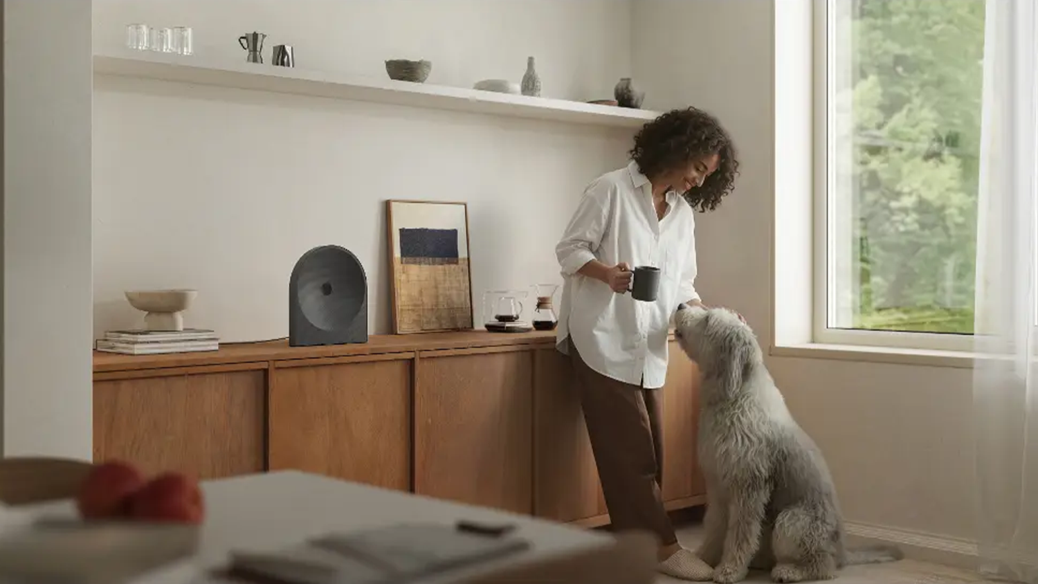 Žena se psem, v popředí reproduktor Samsung