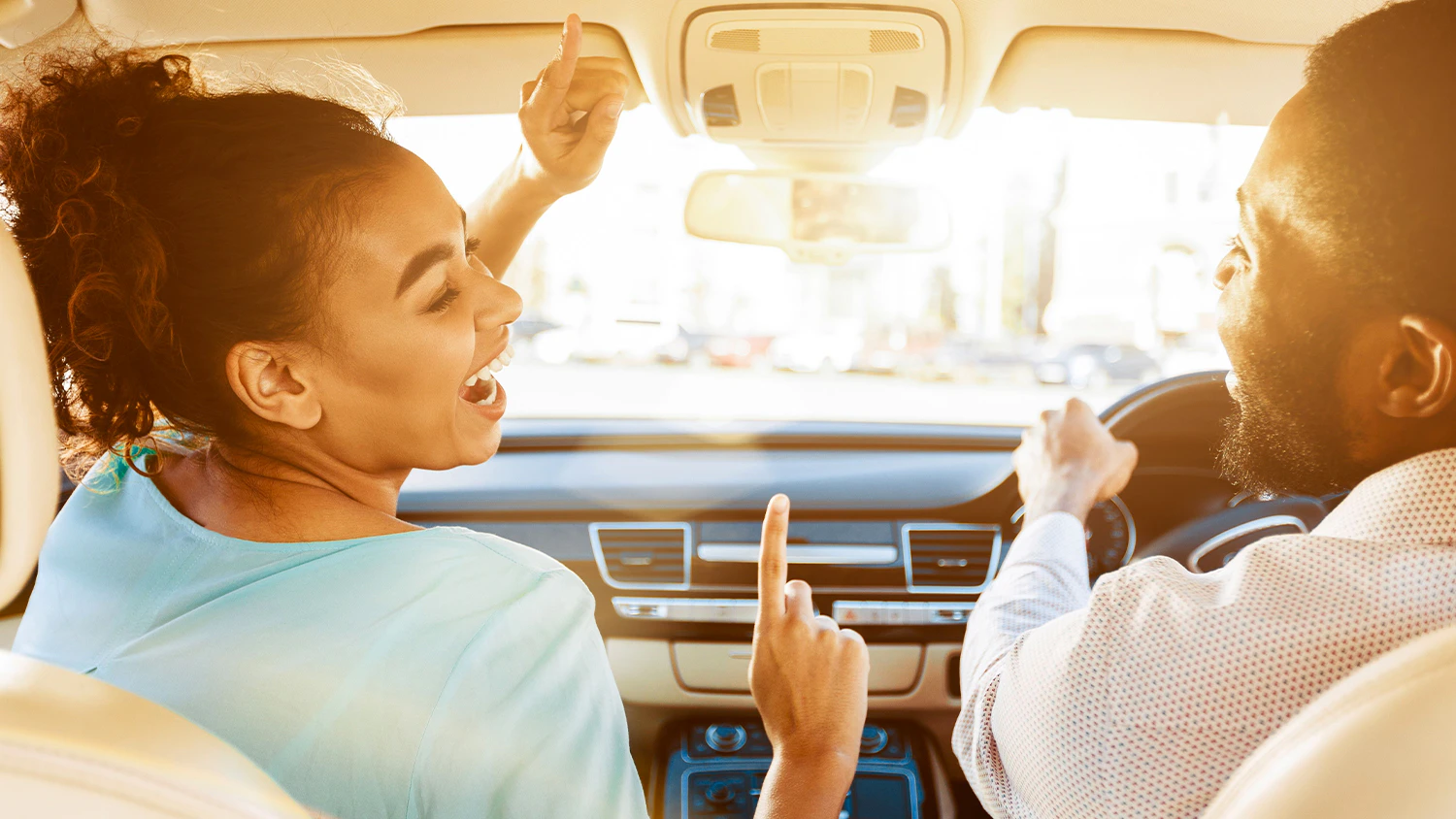 Man and woman enjoying music in a car