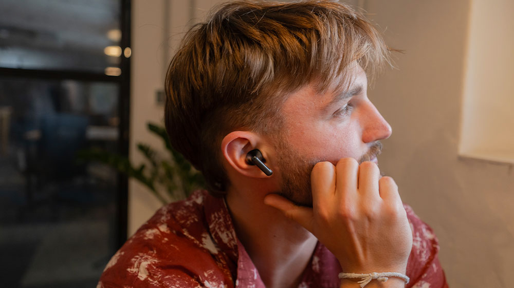 Žena si vkládá sluchátko do ucha_02