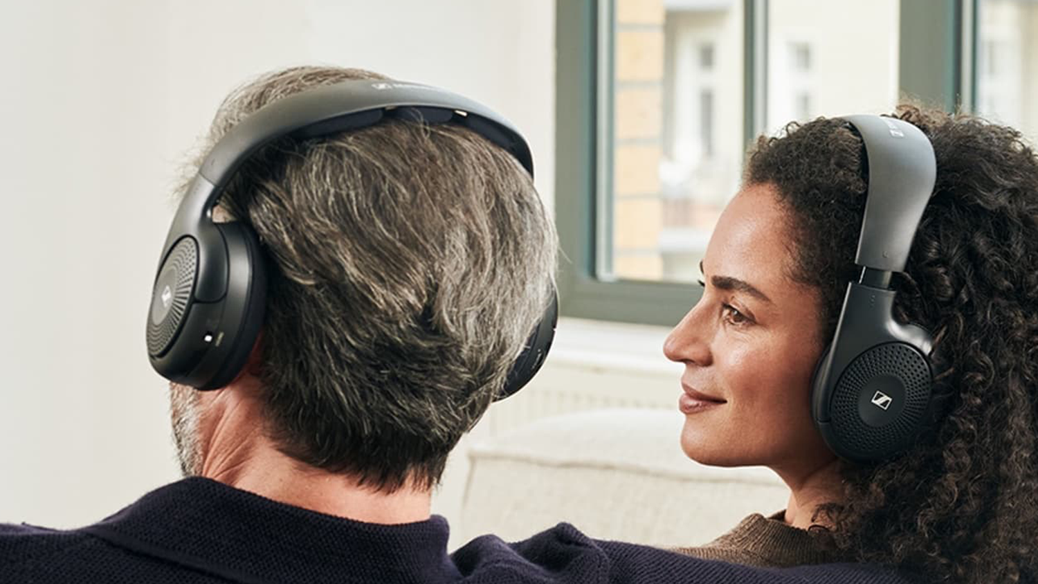 Žena a muž zo zadnej strany so sl&uacute;chadlami Sennheiser RS 120-W