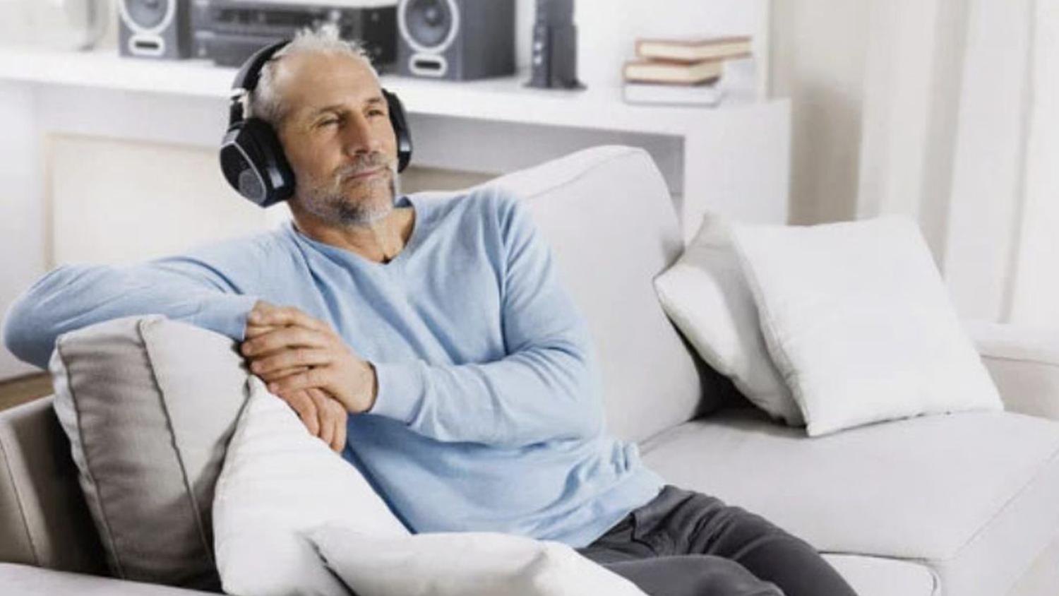 Muž na pohovce se sluch&aacute;tky Sennheiser RS 195
