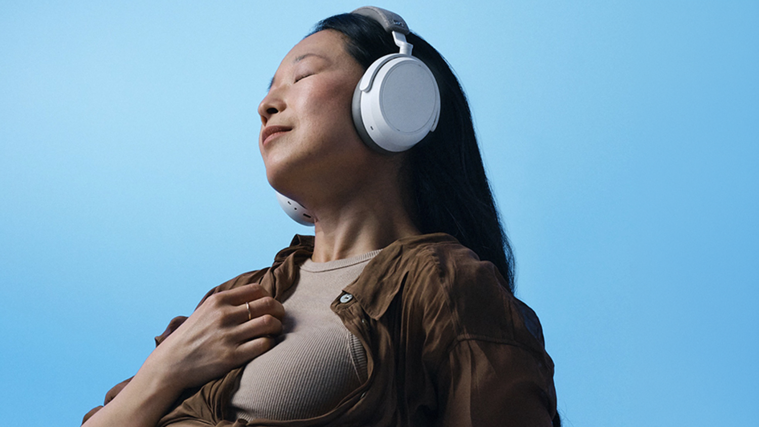 Žena so zavretými očami a Sennheiser MOMENTUM 4 Wireless