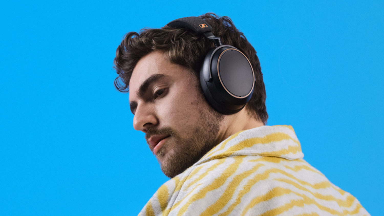Profil muža so slúchadlami Sennheiser MOMENTUM 4 Wireless