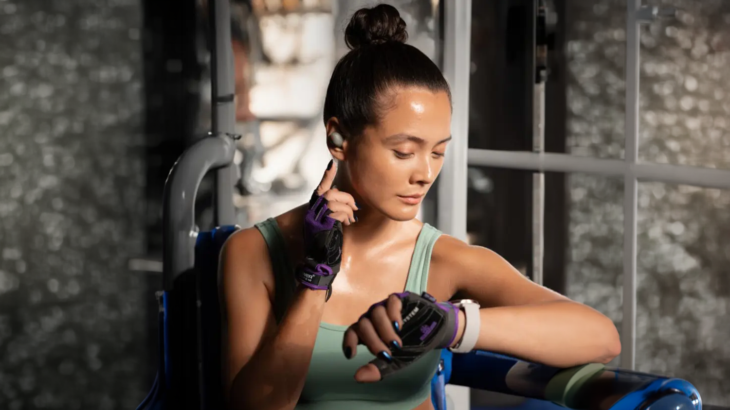 Žena v posilňovni sa slúchadlami Sennheiser MOMENTUM Sport