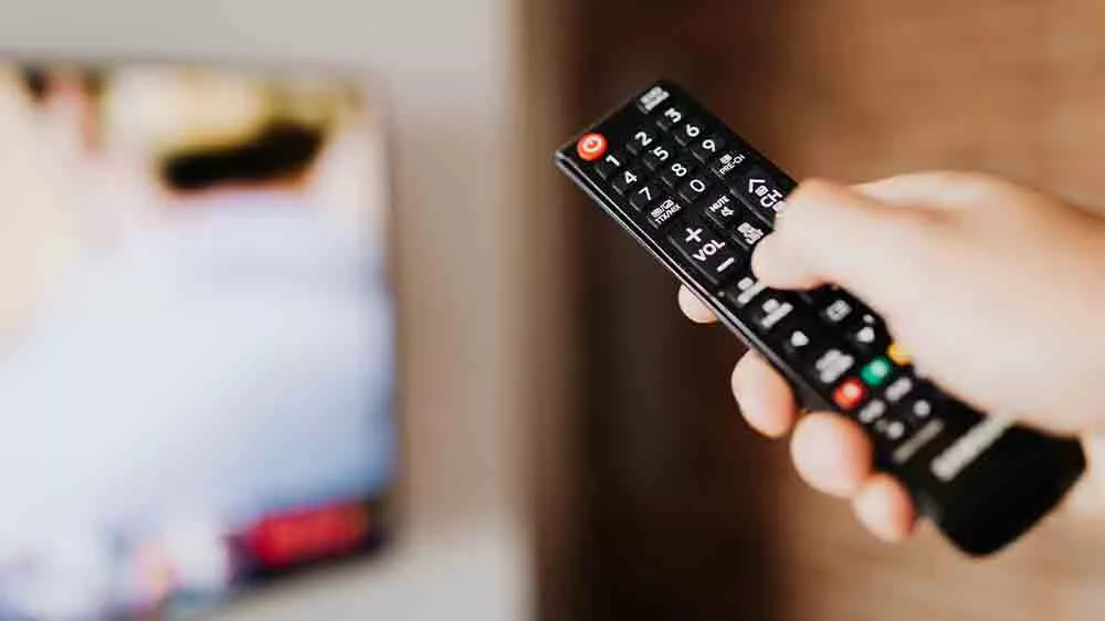 Ruka mířící ovladačem na televizi_04