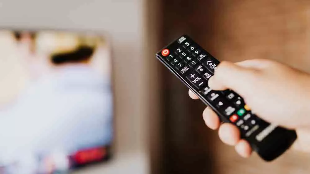 Ruka mířící ovladačem na televizi_04