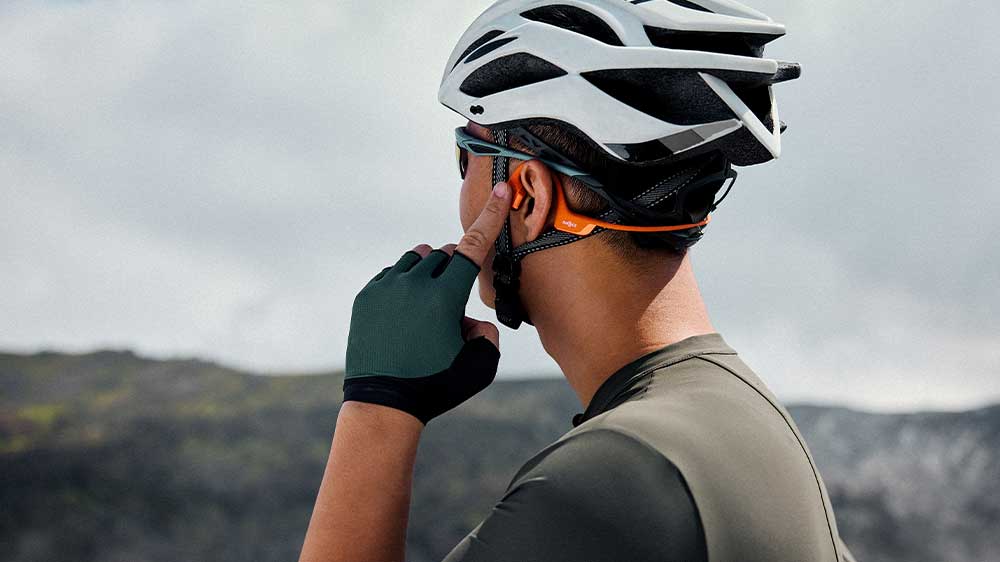 Muž v cyklistick&eacute; helmě se sluch&aacute;tky Shokz OpenRun Pro 2_02