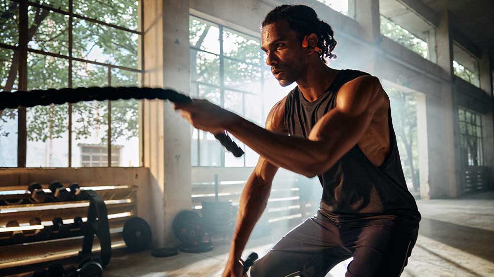 Muž v posilovně se sluch&aacute;tky Shokz OpenRun Pro 2_03