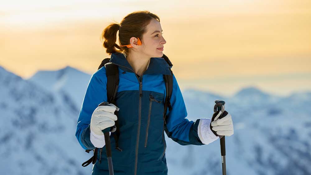 Žena při zimn&iacute;m v&yacute;stupu na hory se sluch&aacute;tky Shokz OpenRun Pro 2_04