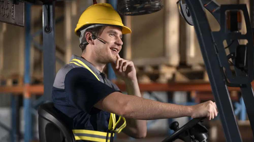 Muž so slúchadlami Shokz OpenComm2 vo vysokozdvižnom vozíku_02