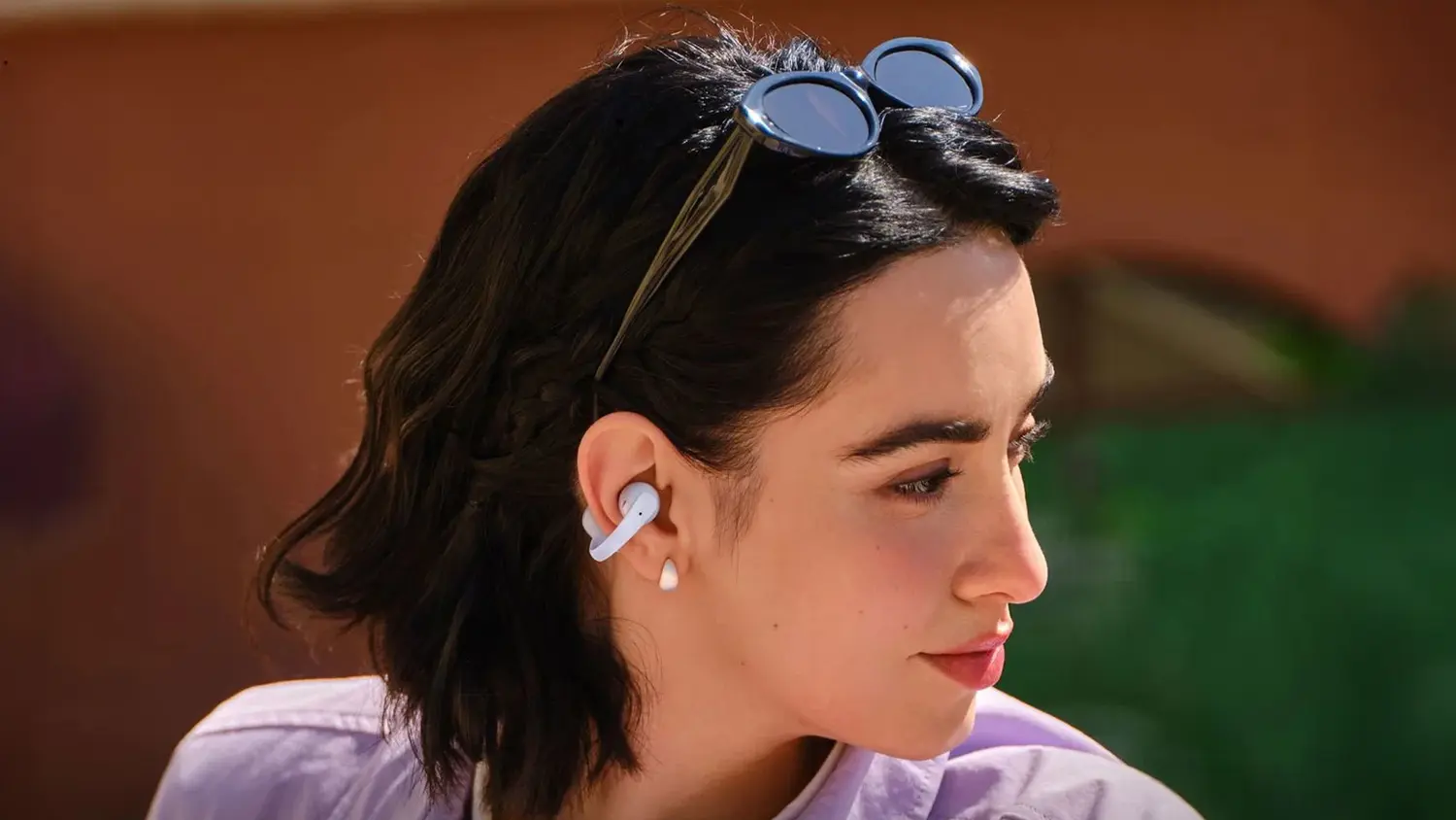 Žena nosí bezdrôtové slúchadlá Shokz OpenDots Air