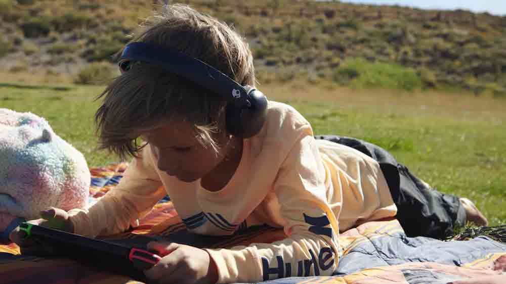 Chlapec hraje na PSP a poslouch&aacute; přes sluch&aacute;tka Skullcandy Grom Wireless Kids_03