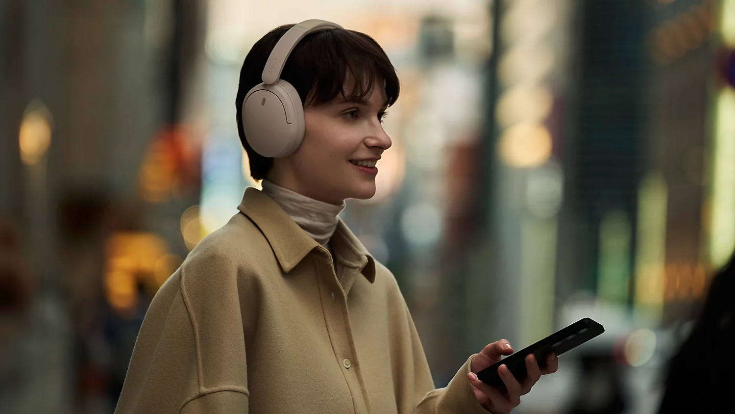 Žena telefonující pomocí sluchátek Sony WH-CH730N