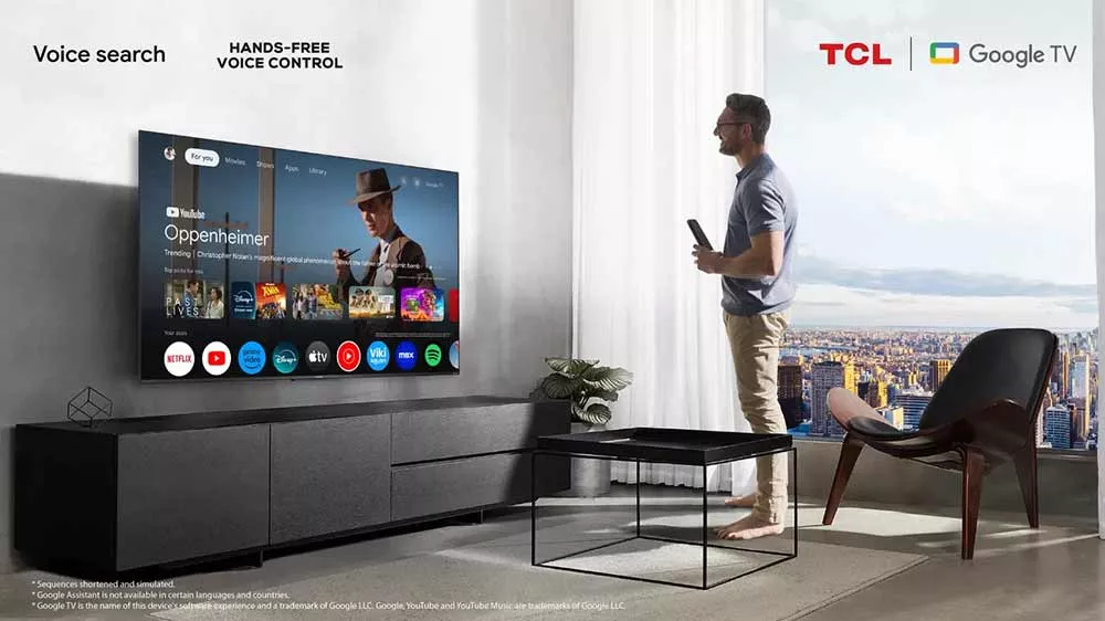 Muž sleduje telev&iacute;zor TCL pripevnen&yacute; na stene