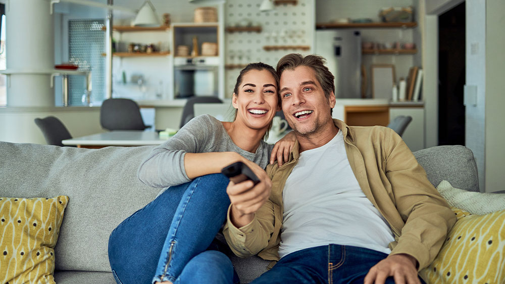 Pár na gauči sleduje televizi_03