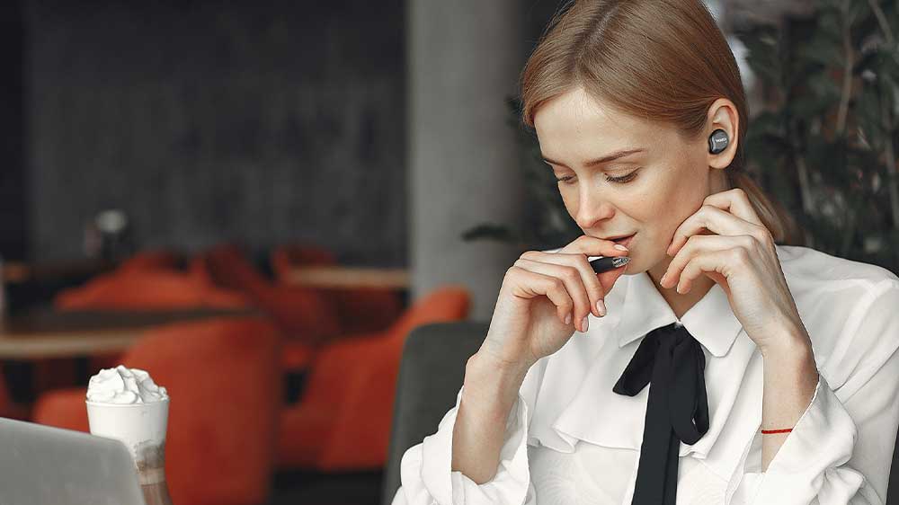 Dívka v kavárně má v uších bezdrátová sluchátka TOZO NC9_04