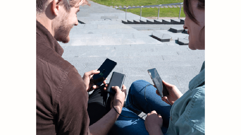 Dva lidé nabíjející svůj telefonu z powerbanky Trust Primo Ultra Thin 15000 mAh ECO_02