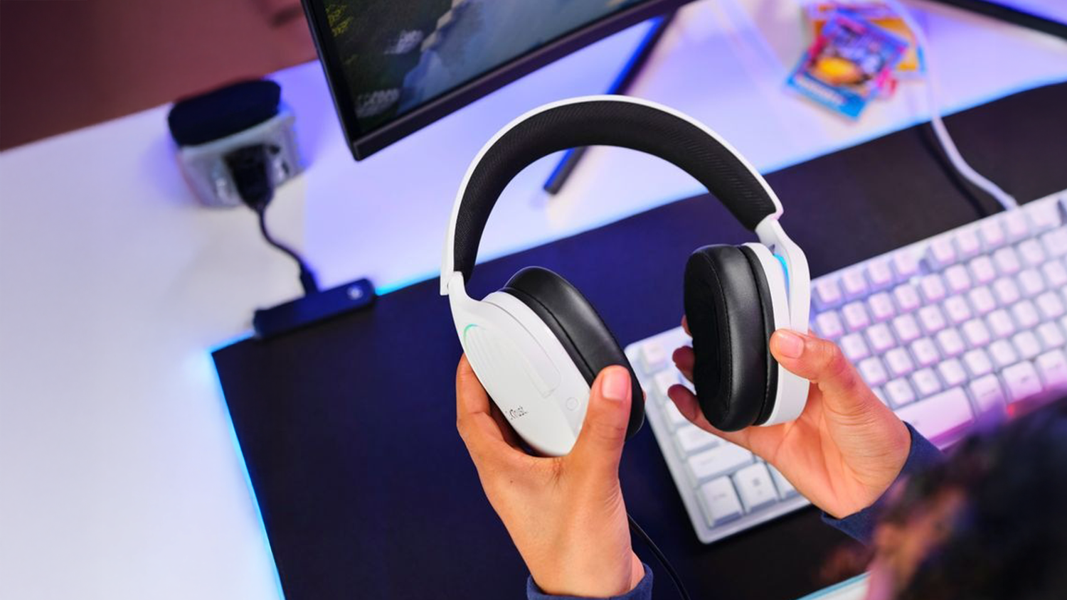 Hr&aacute;č držia v ruke sl&uacute;chadl&aacute; Trust nad kl&aacute;vesnicou