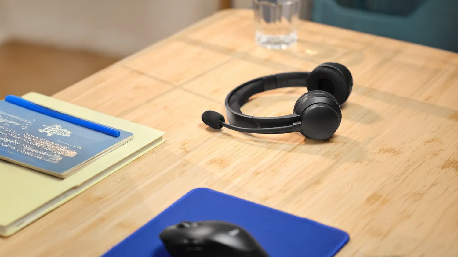 Sl&uacute;chadl&aacute; k PC Trust Ayda Wireless položen&eacute; vedľa my&scaron;i na pracovnom stole