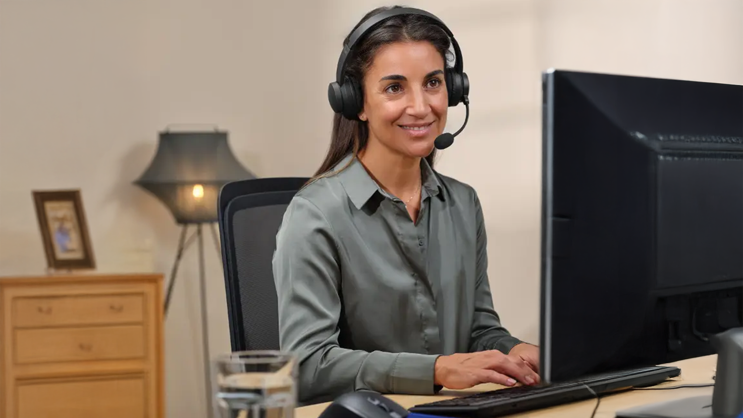 Žena pracuje na PC a m&aacute; nasaden&eacute; sl&uacute;chadl&aacute; Trust Ayda Wireless