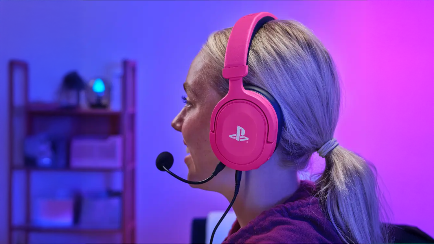 Žena m&aacute; na hlavě hern&iacute; sluch&aacute;tka Trust GXT 498P Forta PS5