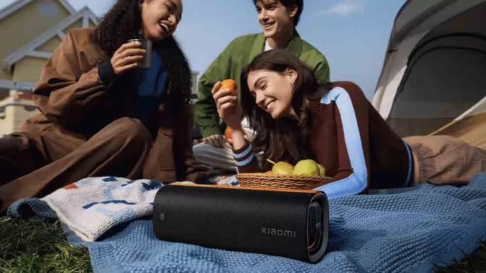 Traja priatelia si už&iacute;vaj&uacute; z&aacute;bavu v stane s reproduktorom Xiaomi Sound Party MDZ-39-DB