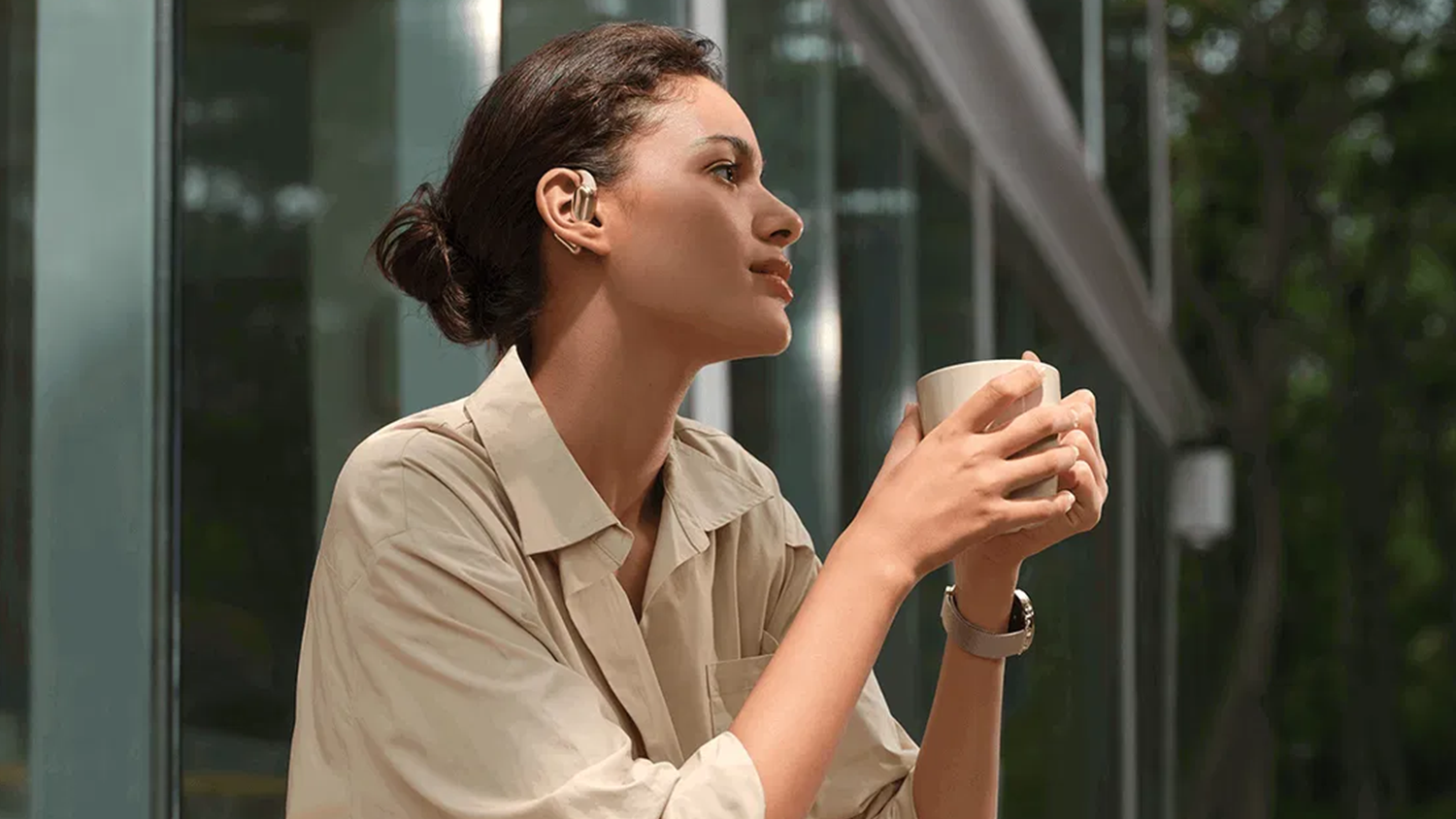 Žena s šálkem kávy a s nasazenými sluchátky Xiaomi OpenWear Stereo Pro