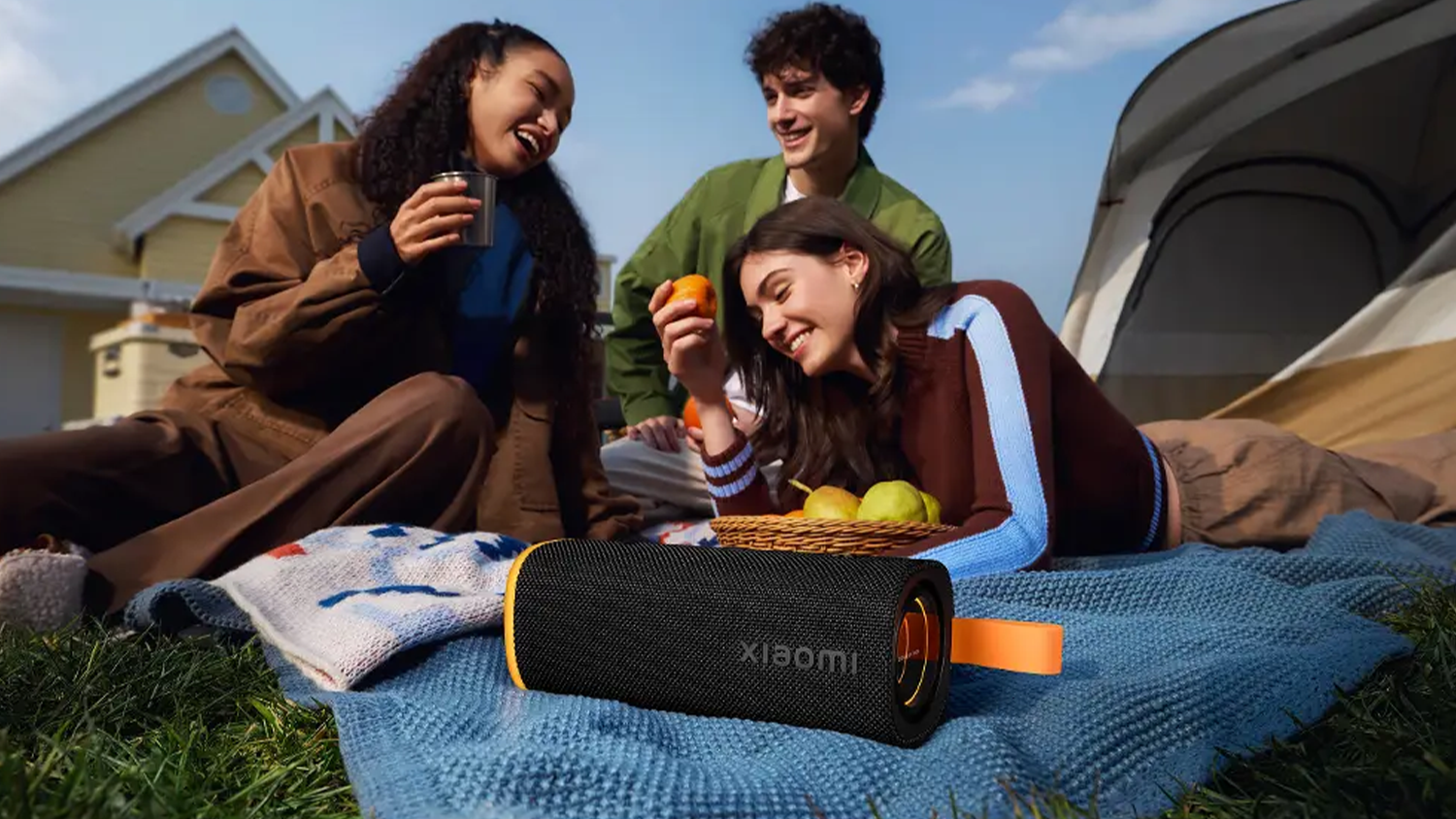 Skupinka mladých lidí poslouchá hudbu z reproduktoru Xiaomi Sound Play