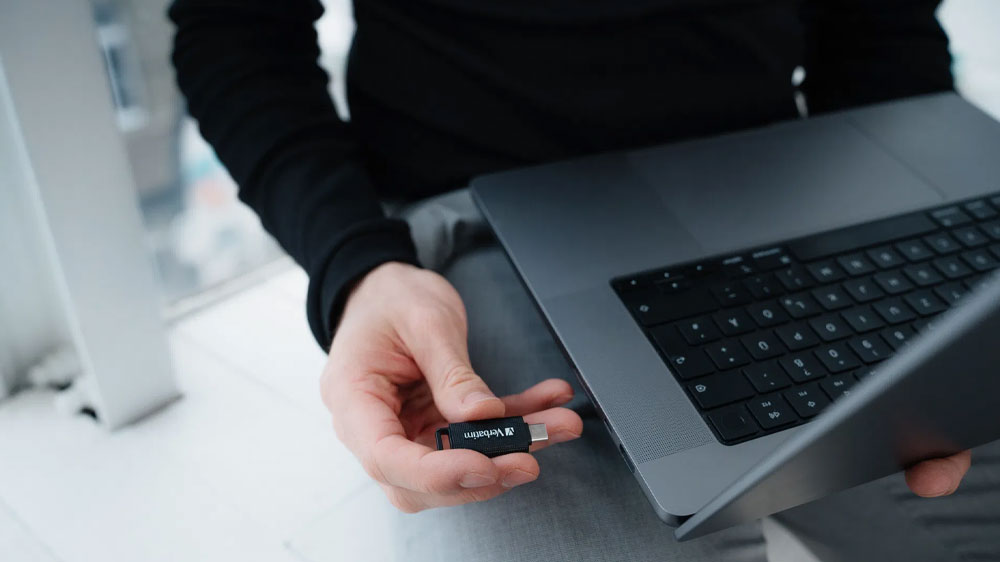 Muž držící USB Flash disk Verbatim připravený na vsunutí do notebooku_02