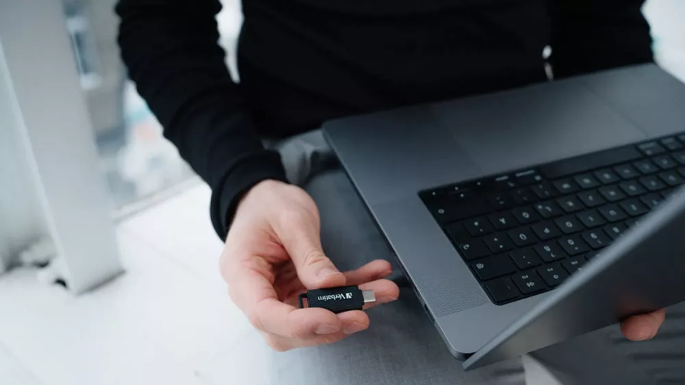 Muž drž&iacute;c&iacute; USB Flash disk Verbatim připraven&yacute; na vsunut&iacute; do notebooku_02