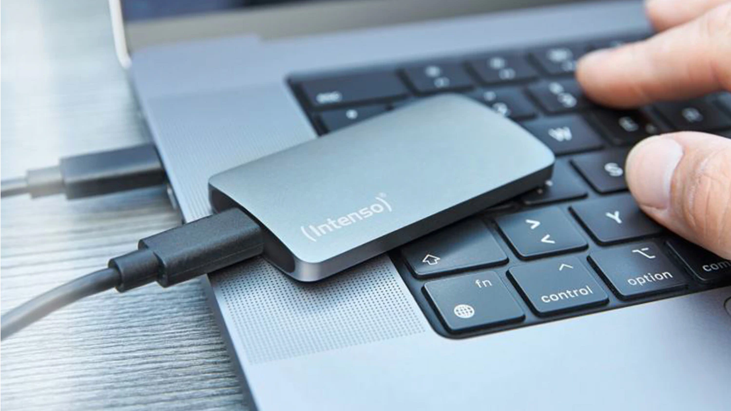 Extern&yacute; SSD disk Intenso TX800 položen&yacute; na notebooku