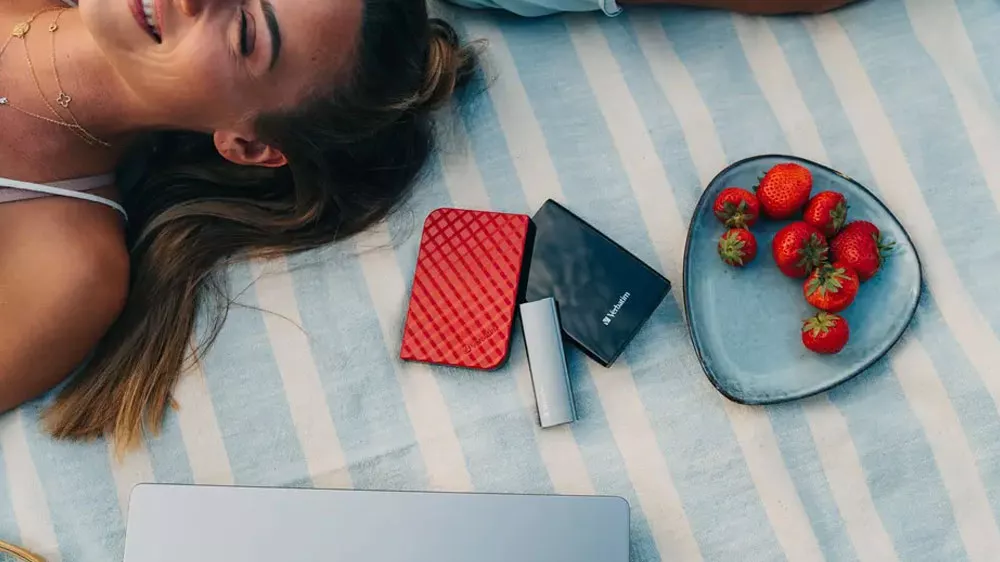 Žena lež&iacute; na dece s extern&iacute;m SSD diskem Verbatim Vx500_03