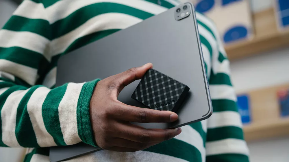 Člověk držící externí SSD disk Verbatim Store 'n' Go Mini Diamond s notebookem_03
