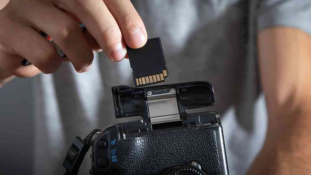 Muž vkládá paměťovou kartu do fotoaparátu_04