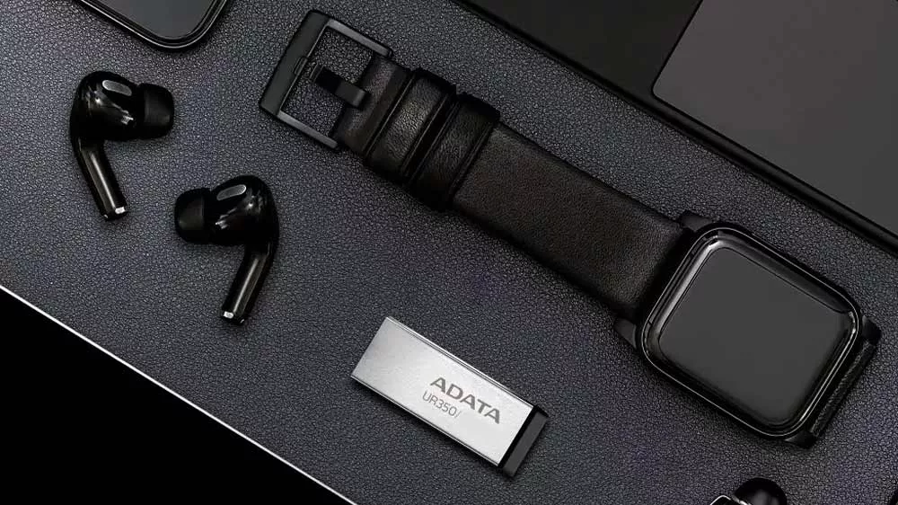 Flash disk Adata UR350 s hodinkami, perem a notebookem na stole_03