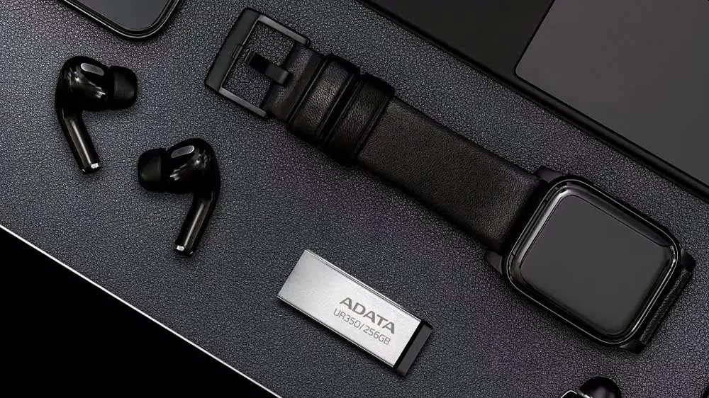 Flash disk Adata UR350 s hodinkami, perem a notebookem na stole_03