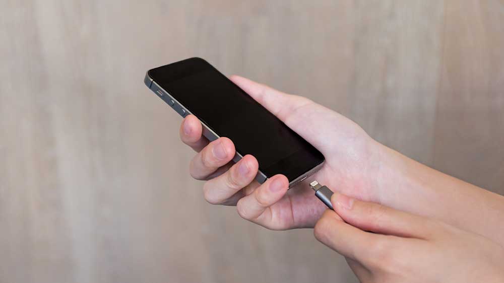 Člověk připojuje kabel do iPhonu_02