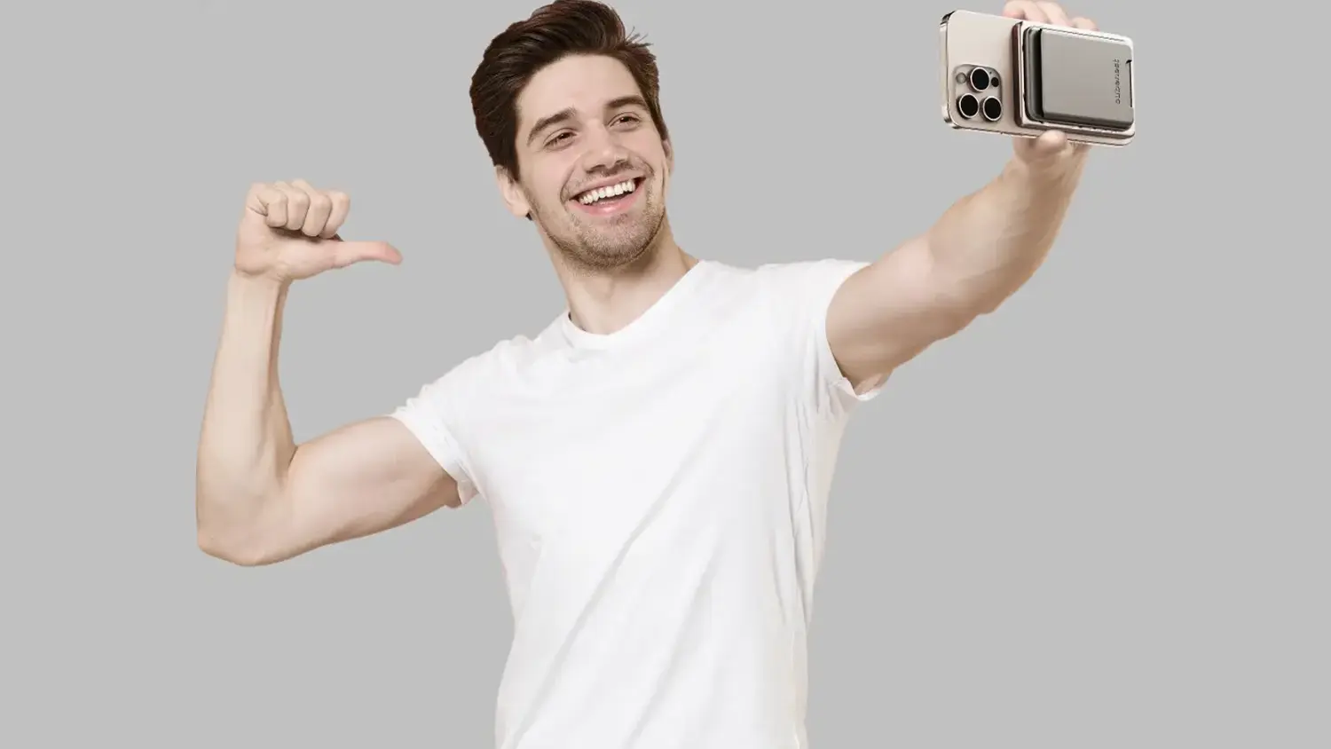 Muž si fotí selfie s telefonem s připevněnou powerbankou a peněženkou