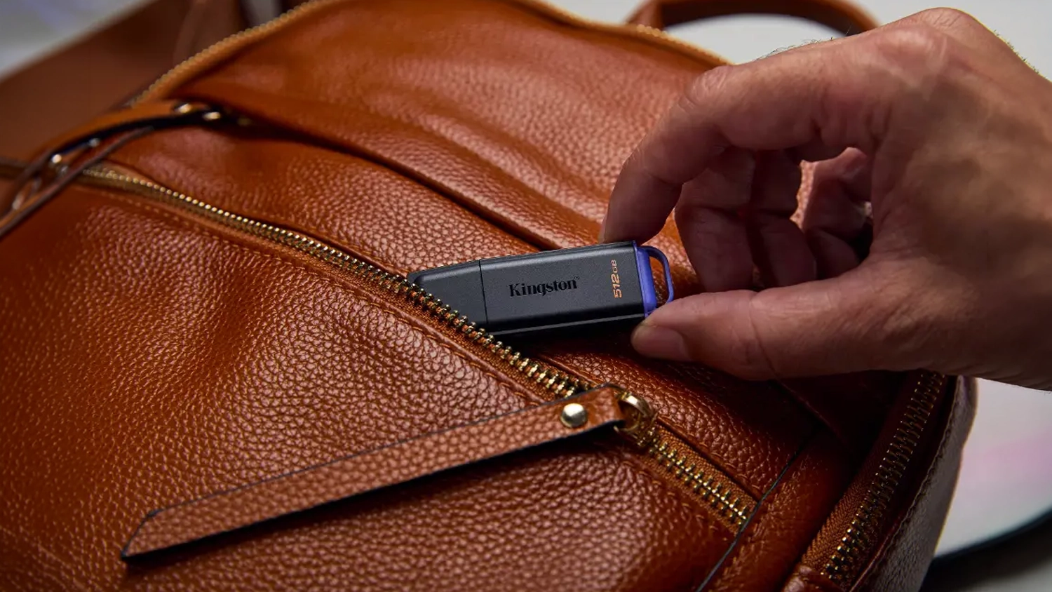 Muž vkl&aacute;d&aacute; flash disk Kingston do ta&scaron;ky