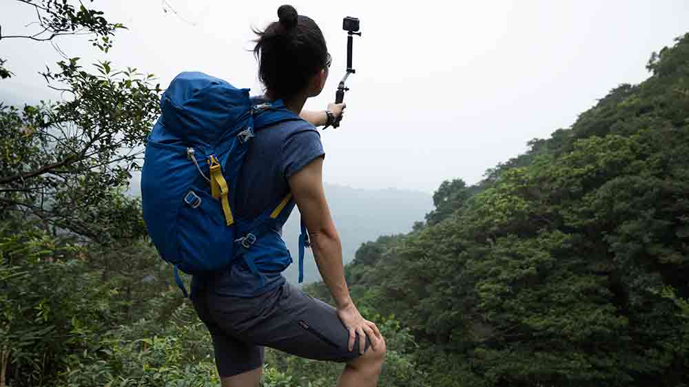 Žena natáčí přírodní scenérii akční kamerou během túry v lese a kopcích_03
